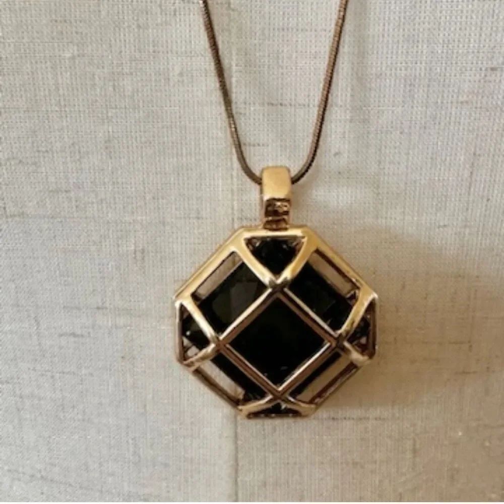 Gold tone pendant necklace with crystal inside